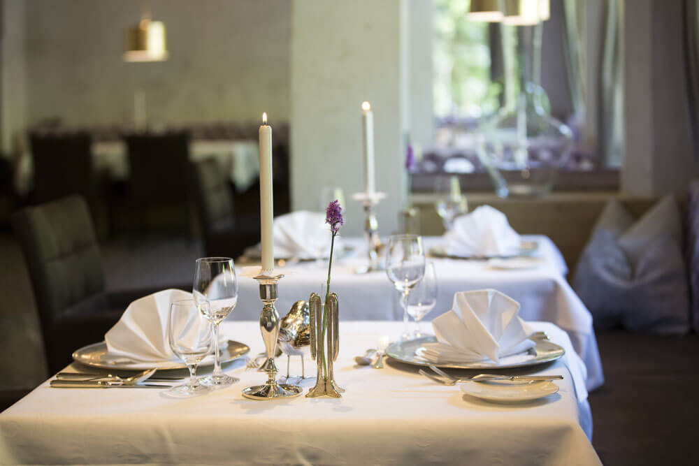 festlich gedeckte Tische mit silbernen Kerzenständern