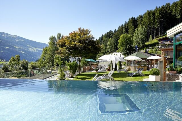 Ansicht Outdoorpool mit Liegen im Sommer