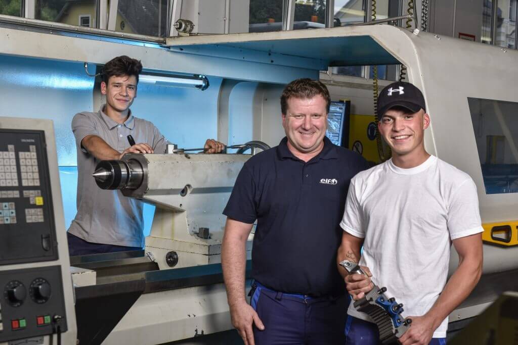 Ausbildner mit Lehrlingen in der Werkstatt