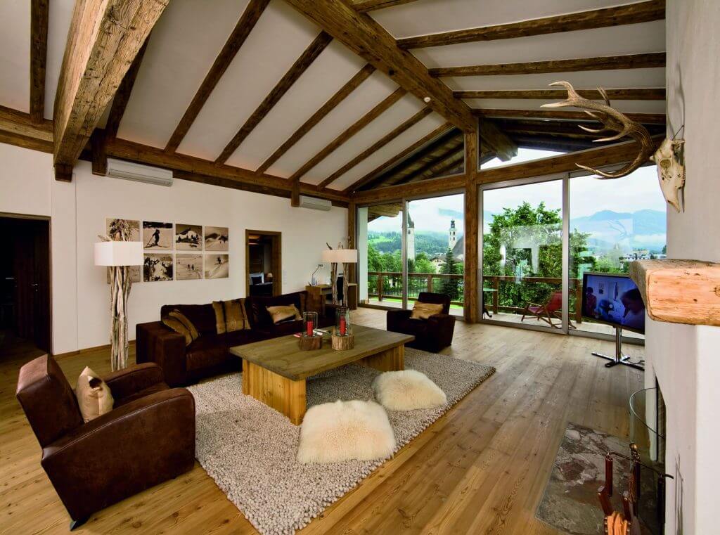 Loft mit dunklen Holzverkleidungen und Aussicht auf die Berge