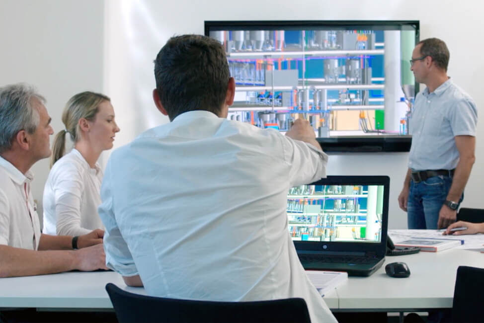 Mitarbeiterbesprechung vor Screen und Laptop