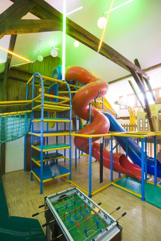 Indoorspielplatz mit roter Rutsche und Fußballtisch